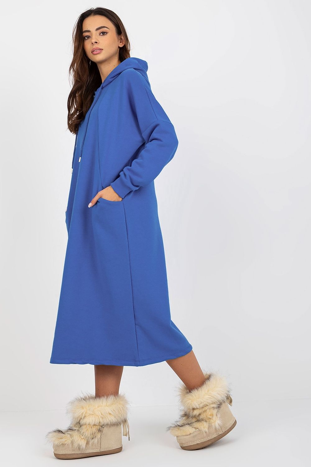 Side view of an elegant blue cotton spandex sweat dress with hood, featuring practical side pockets and paired with stylish fuzzy footwear.