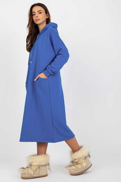 Side view of an elegant blue cotton spandex sweat dress with hood, featuring practical side pockets and paired with stylish fuzzy footwear.