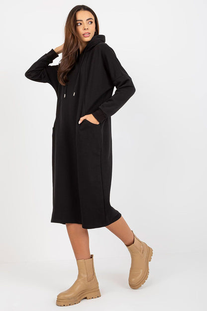 Chic black cotton spandex sweat dress with hood, elegantly designed for a luxurious look, complemented by trendy tan ankle boots.