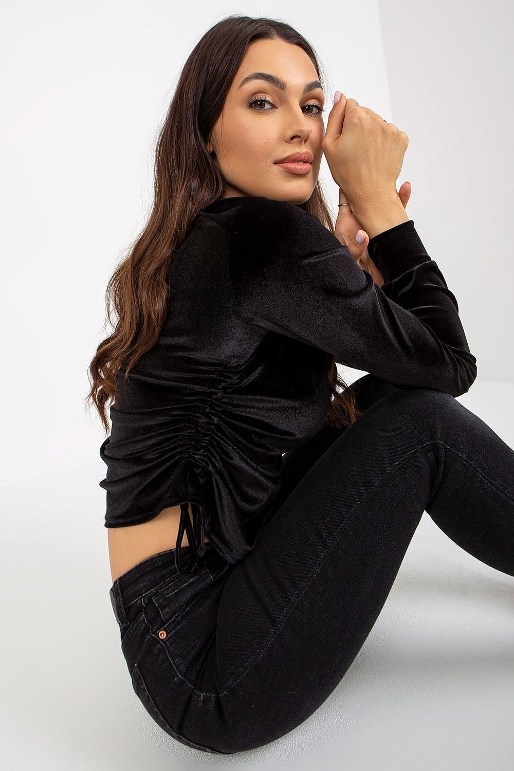 Chic black velour blouse showcased from behind, with detailed side ties, highlighting a stylish and sophisticated design.