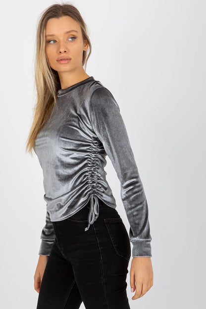 Chic front view of a grey velour blouse with long sleeves and side ruching, embodying modern luxury and style.