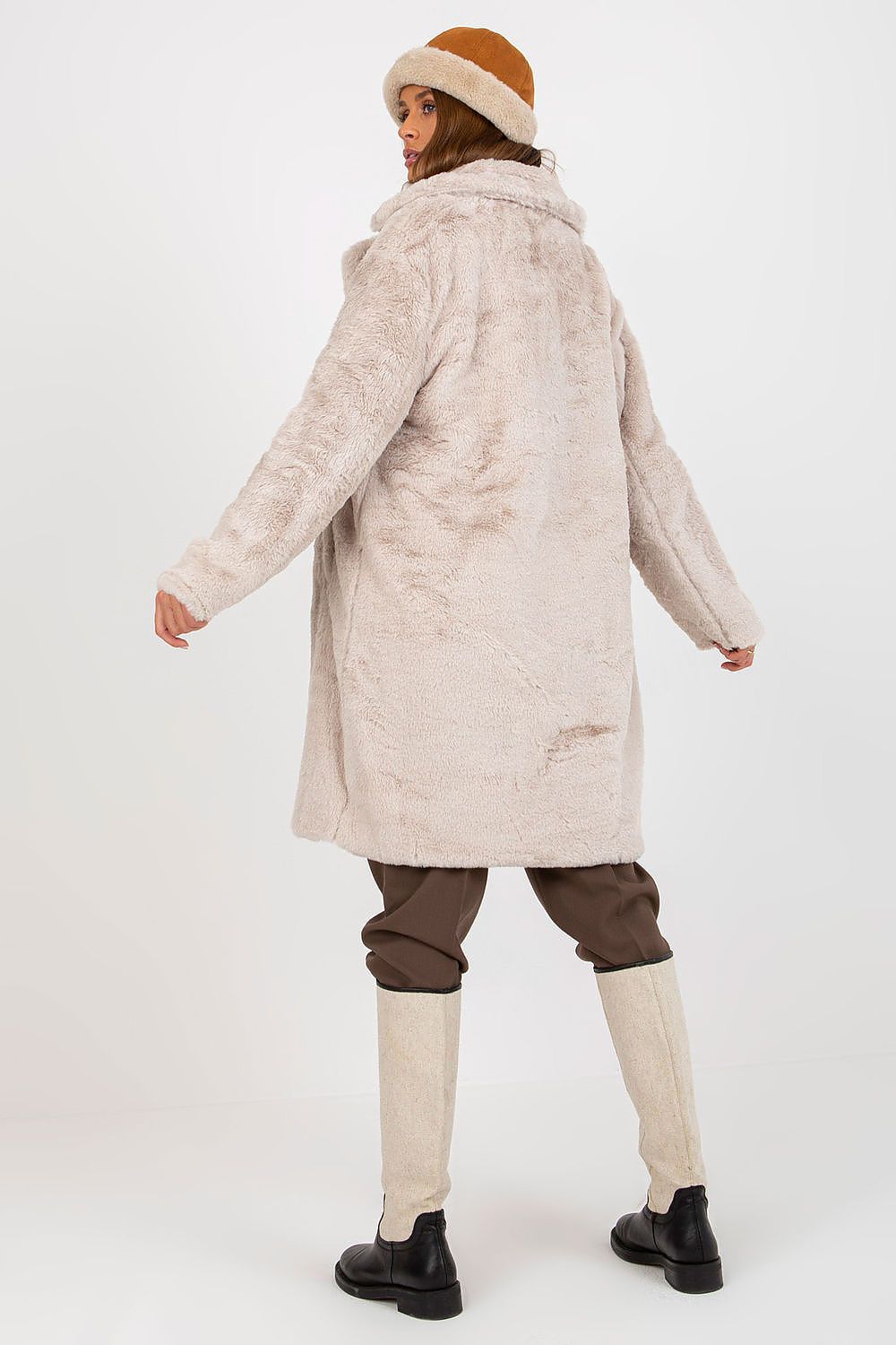 Luxurious long sleeve fur coat in soft beige, featuring a plush texture and elegant silhouette, worn with stylish cropped trousers and knee-high boots, exuding sophistication and warmth.