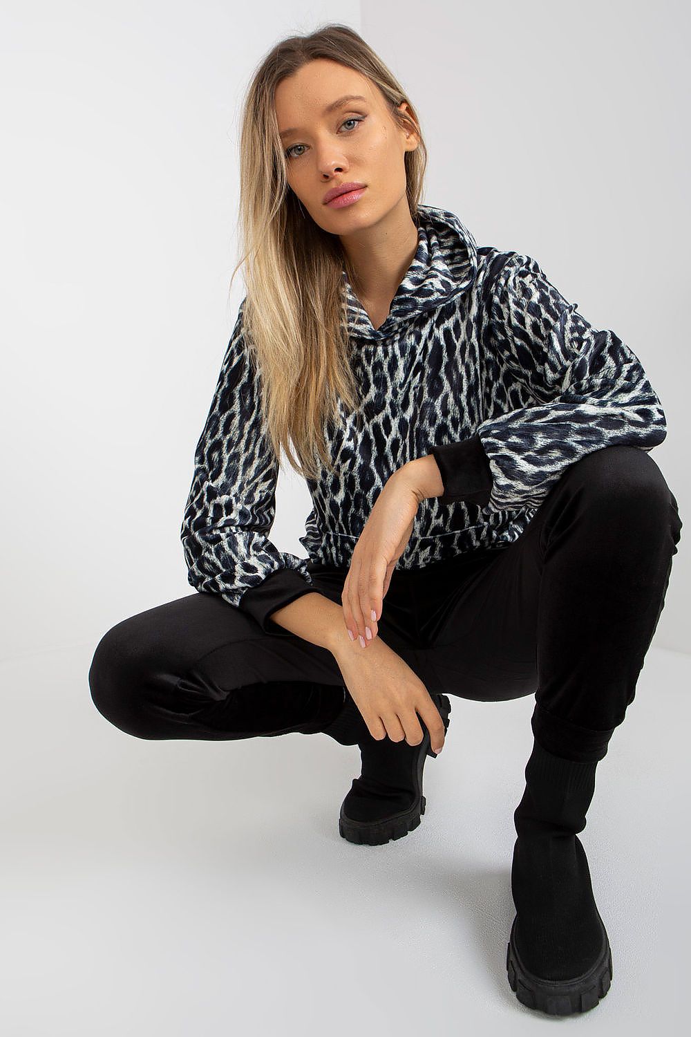 Sophisticated view of a model in the Luxurious Rue Paris Velour Set, featuring an animal print sweatshirt and fitted black velour pants, emphasizing comfort and style.