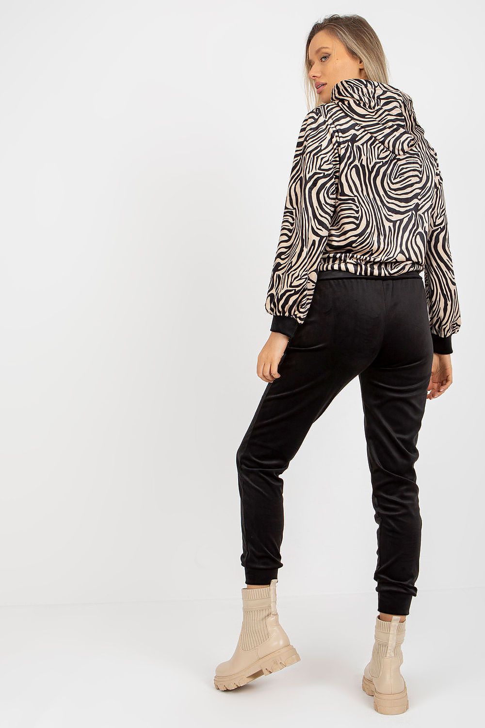Back view of a model wearing the Rue Paris velour set with an eye-catching animal print sweatshirt and sleek black trousers, perfectly styled for comfort and luxury.