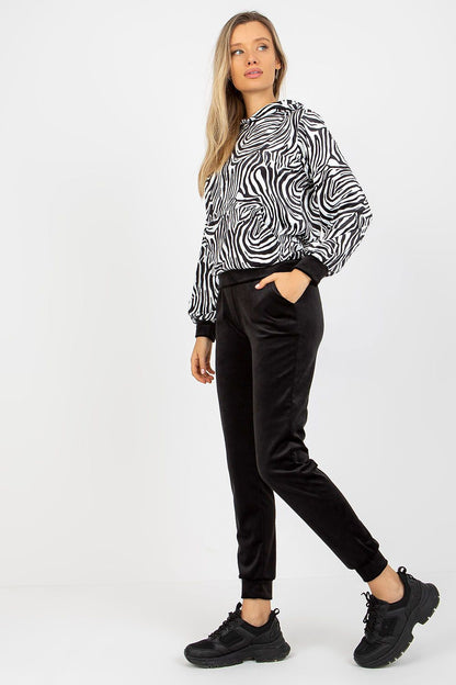 Fashion-forward model in the Rue Paris animal print velour set, pairing the outfit with sporty black shoes, embodying an effortless blend of luxury and casual wear.