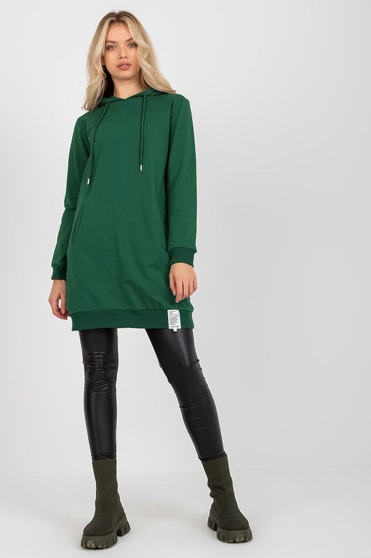 Elegant green women's hooded sweat dress, featuring a modern design with long sleeves and practical slip pockets, paired with sleek black leggings and stylish ankle boots.