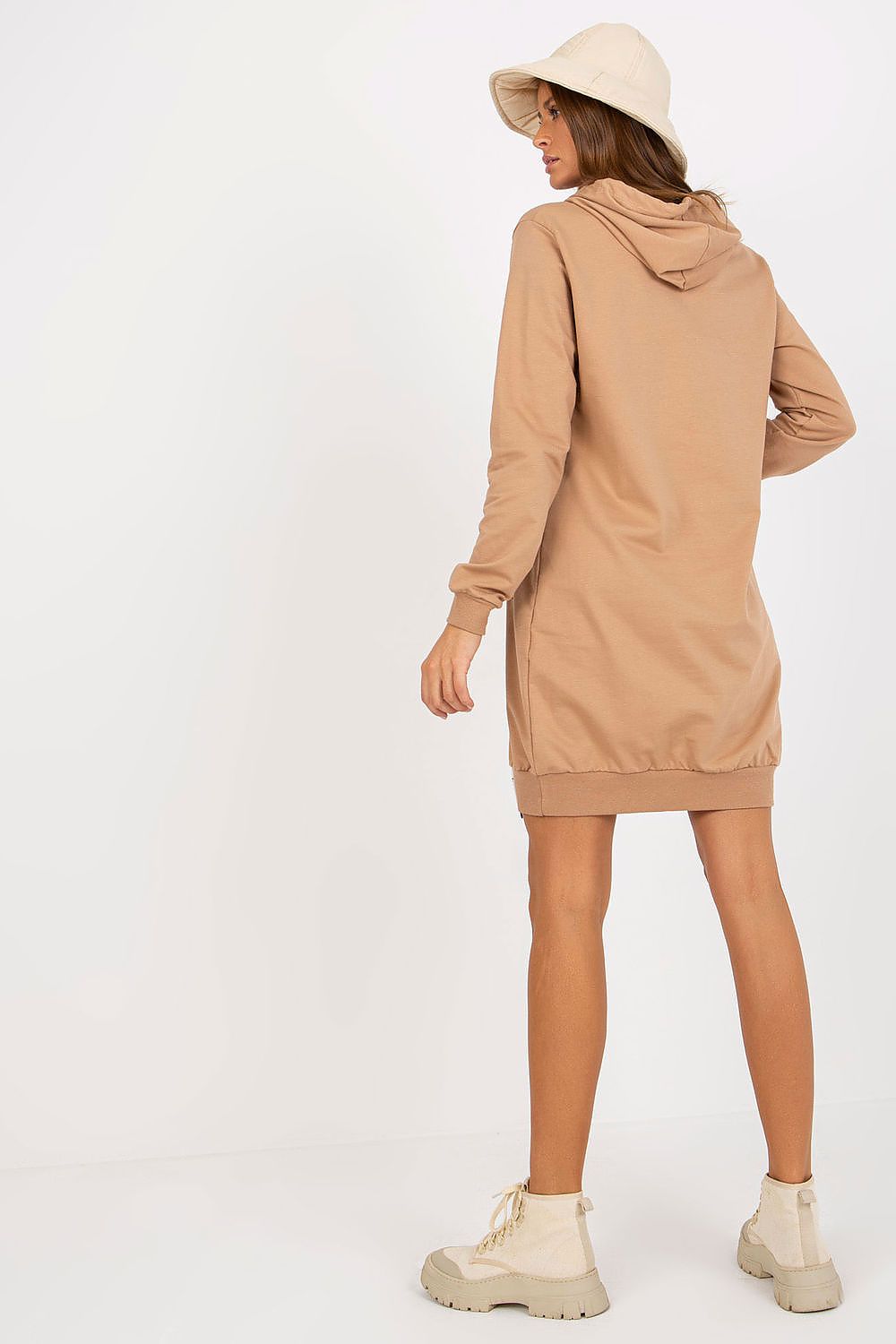 Back view of a fashionable woman in a light brown hooded sweat dress, complemented by stylish footwear for a modern look.