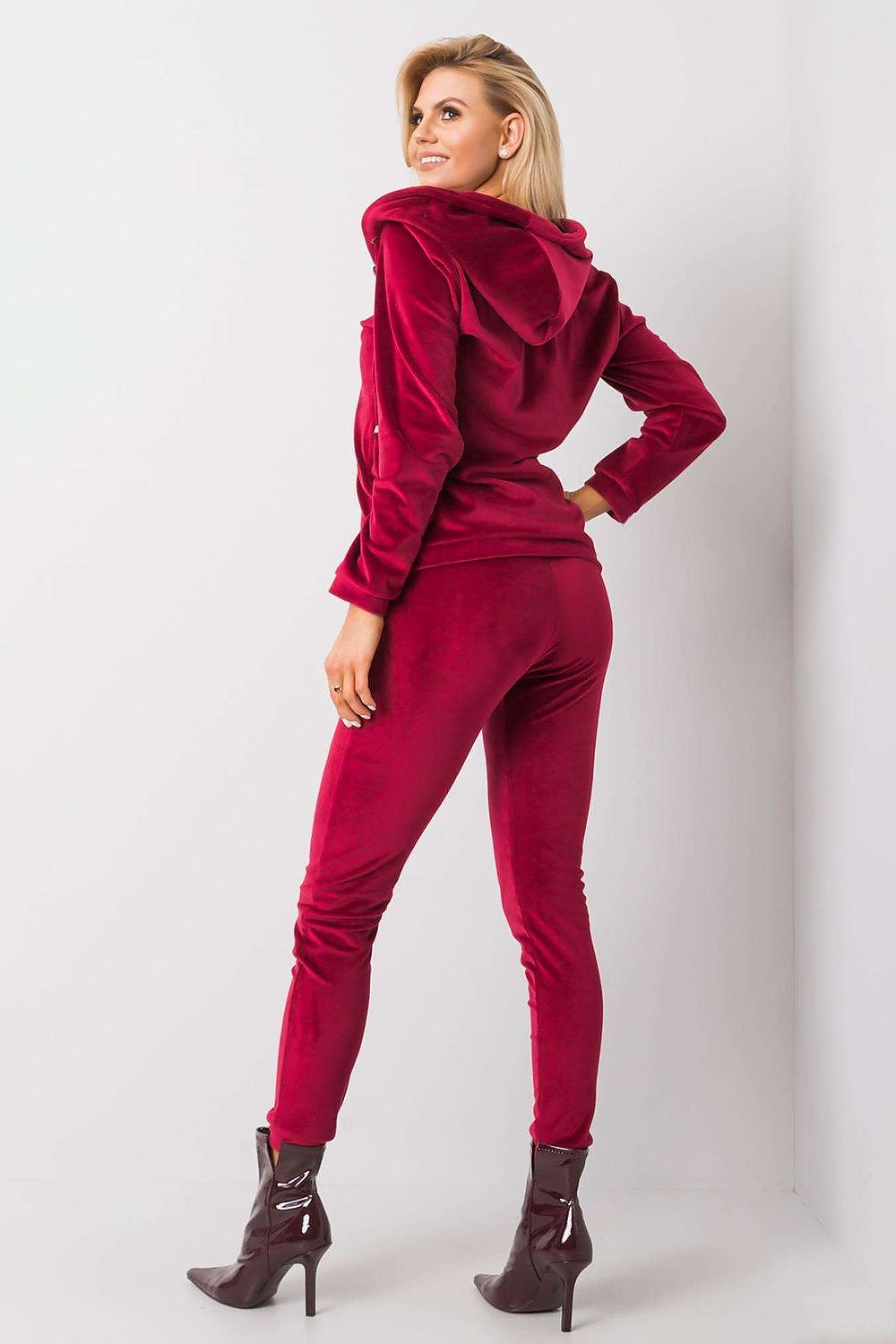 Sophisticated view of a burgundy velour two-piece set on a model, emphasising the stylish back design of the hooded sweatshirt and sleek pants.