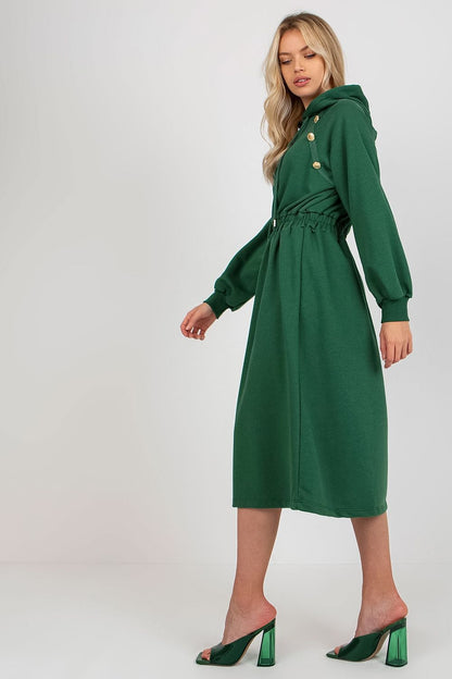 Side view of a sophisticated lady in a green cotton hoodie dress, designed with long sleeves and a cinched waist, exuding effortless chic style for casual outings.
