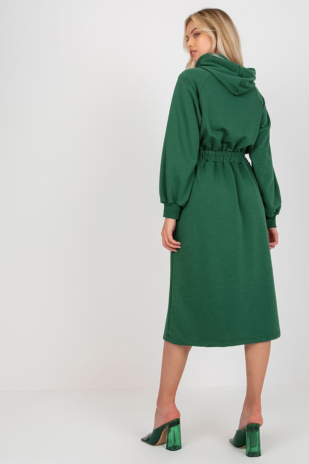 Back view of a stylish woman wearing a green cotton hoodie dress, highlighting the relaxed fit and modern design, ideal for luxury casual fashion.