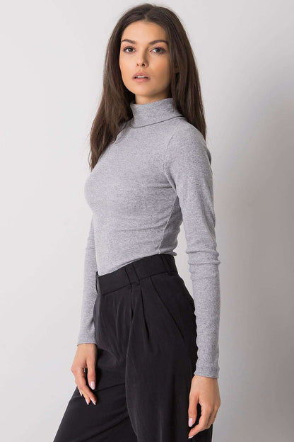 Sophisticated side profile of a grey turtleneck, elegantly paired with tailored trousers, perfect for a stylish casual look.
