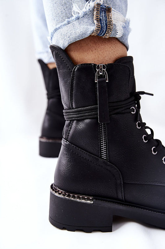 Close-up detail of luxurious black worker boots with dual zippers and decorative heel elements, designed for both comfort and style.