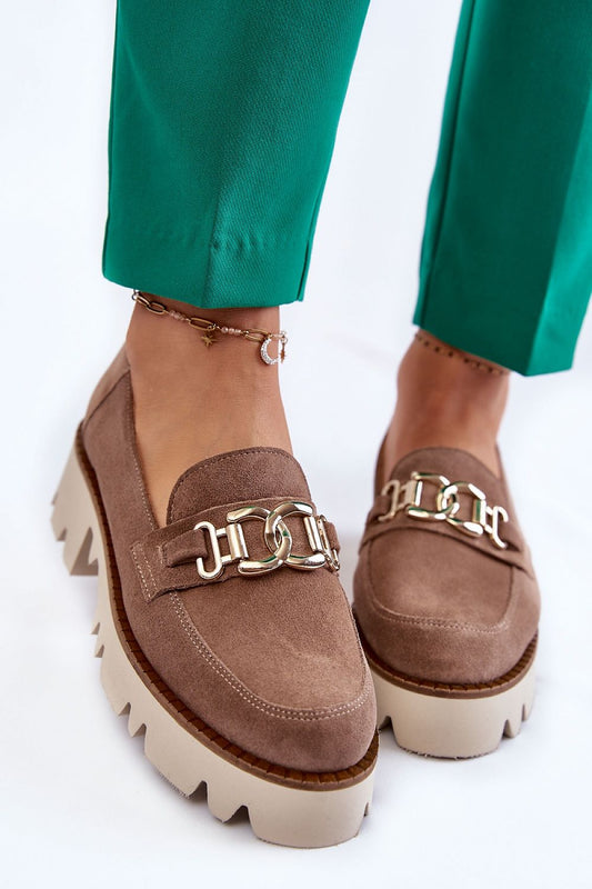 Luxury half shoes made of suede leather featuring a comfortable insole and decorative front, styled elegantly with green trousers.