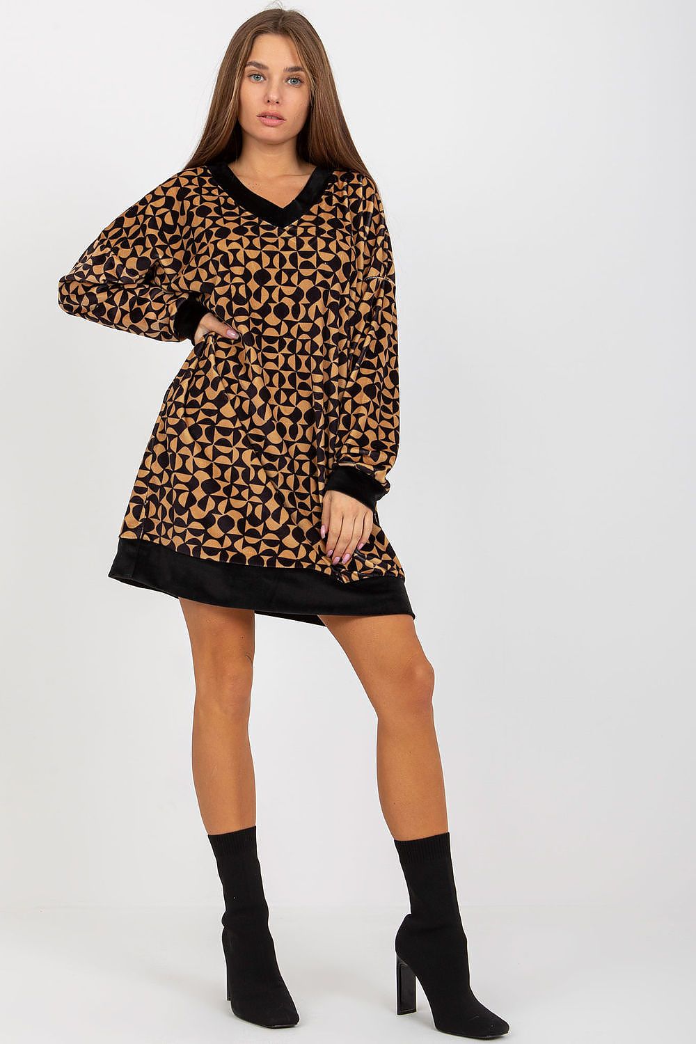 Elegantly styled short velour dress featuring a geometric pattern, long sleeves, and a heart neckline, complemented by chic black ankle boots.