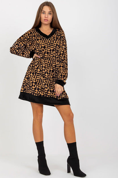 Elegantly styled short velour dress featuring a geometric pattern, long sleeves, and a heart neckline, complemented by chic black ankle boots.