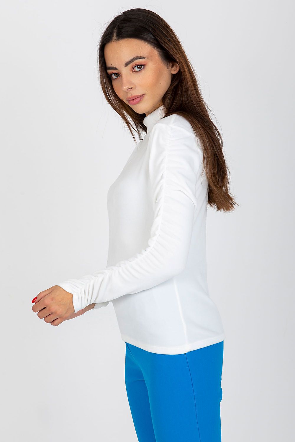 Elegant white velour blouse with long sleeves and stand-up collar, featuring a fitted silhouette modelled by a woman.