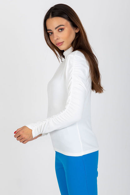 Elegant white velour blouse with long sleeves and stand-up collar, featuring a fitted silhouette modelled by a woman.