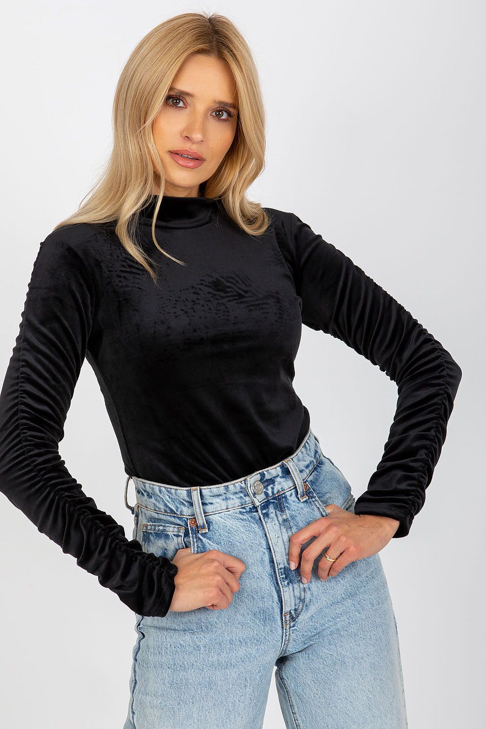 Elegant black velour blouse featuring long sleeves with chic creased details and a stylish stand-up collar, modelled with relaxed denim.