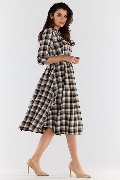 Side profile of an elegant woman in a checkered midi dress, capturing the graceful flow of the fabric and the sophisticated silhouette, perfect for chic occasions.