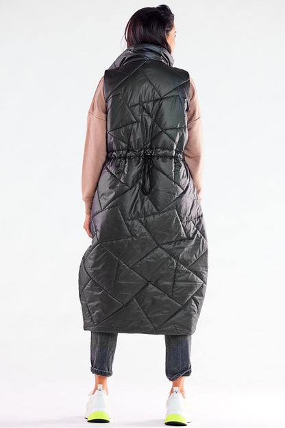 Back view of a fashionable model wearing the Awama oversized vest in black, highlighting the adjustable waist and quilted design, ideal for stylish autumn wear.