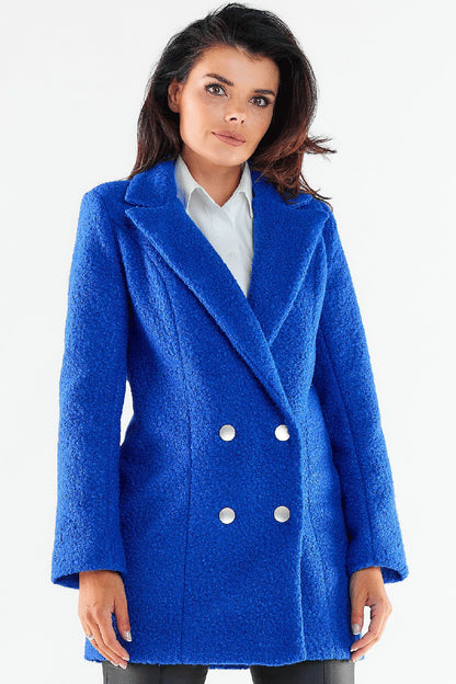 Sophisticated woman modeling a vibrant blue double-breasted coat with shiny buttons, radiating chic style and warmth.