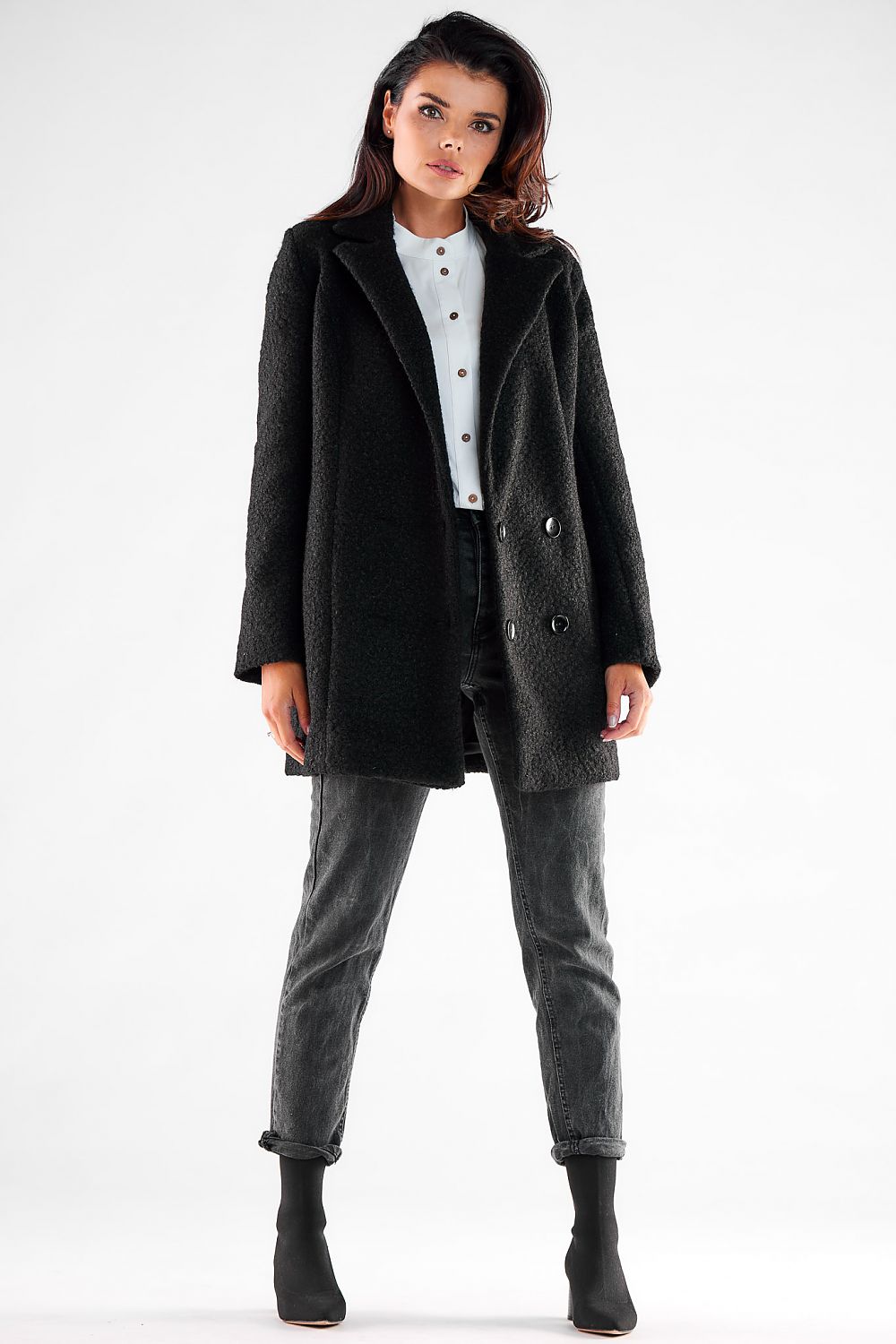 Front view of a sophisticated double-breasted Awama coat on a model, displaying its luxurious fabric and large black buttons, ideal for fashionable layering.