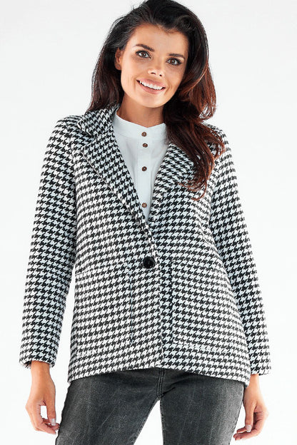Elegant Awama jacket in black and white houndstooth pattern, featuring a stylish large button and chic square pockets. Paired with a crisp white shirt, exuding luxury and sophistication.