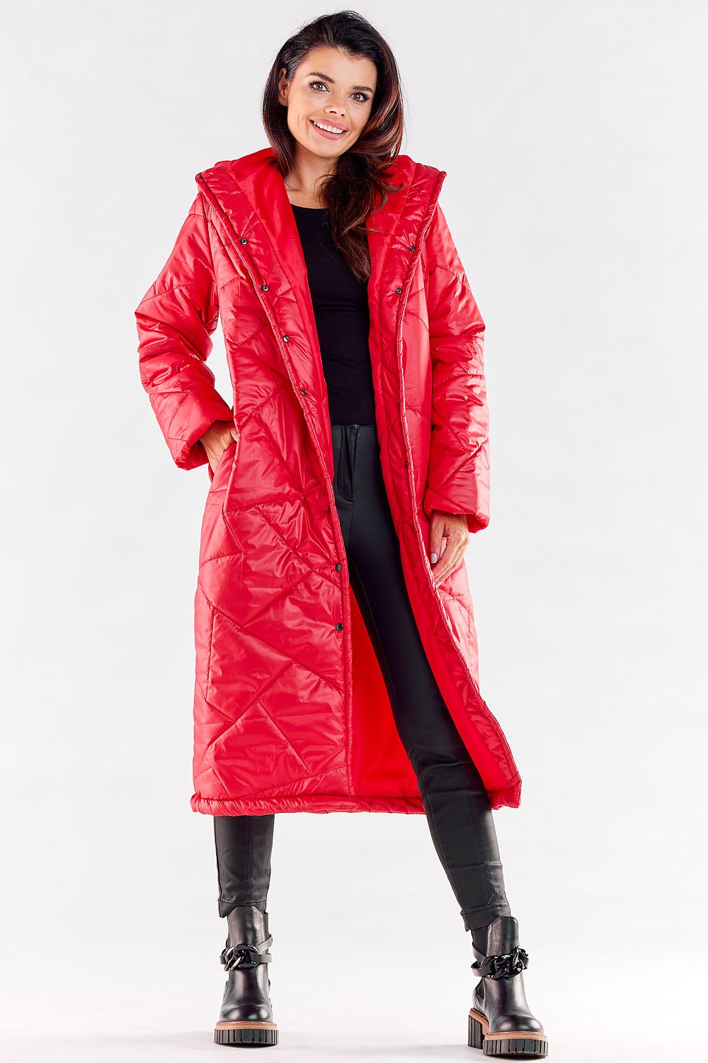 Chic red long quilted coat with a stylish hood, perfect for layering in cooler seasons. Paired elegantly with black leather bottoms and stylish footwear.