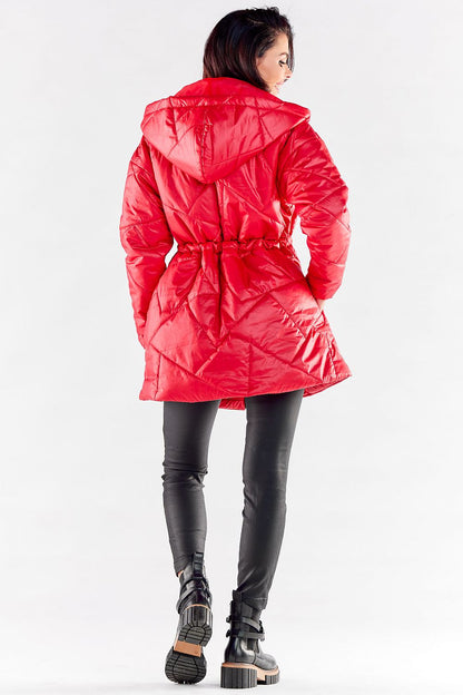 Sophisticated view of a woman elegantly dressed in a luxurious red quilted jacket with a hood, highlighting the stylish adjustable waist design and modern aesthetics.
