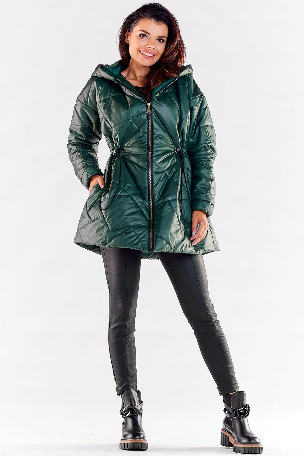 Trendy female model in a luxurious green hooded quilted jacket, presenting an exquisite silhouette with adjustable waist ties, elegantly blending style and comfort.