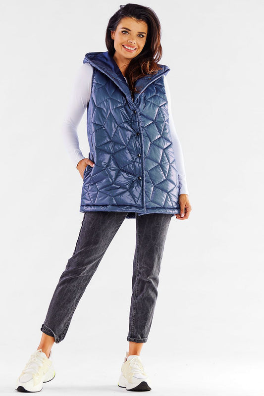 Stylish model showcasing a luxurious navy blue quilted hooded vest by Awama, designed for autumn elegance, paired with casual denim trousers and sporty shoes.