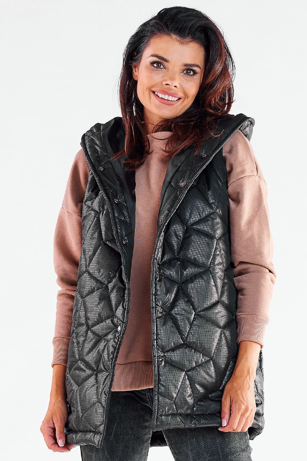 Elegant model wearing a black quilted hooded vest by Awama, complemented with a soft pink sweater, exuding sophistication and warmth for autumn styling.