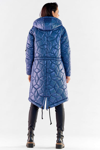 Back view of a fashionable woman in a blue quilted knee-length jacket with hood, highlighting the stylish design and shape.