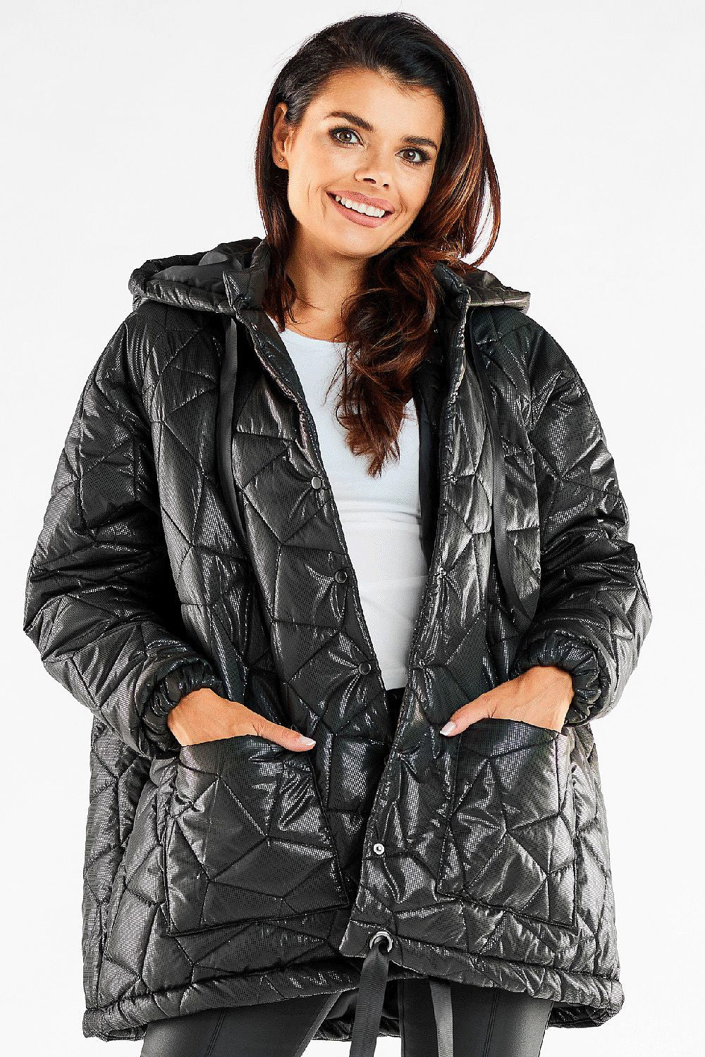 Elegant woman wearing a luxury oversized quilted jacket with adjustable hood and front pockets, showcasing a stylish quilted pattern, perfect for a chic winter look.
