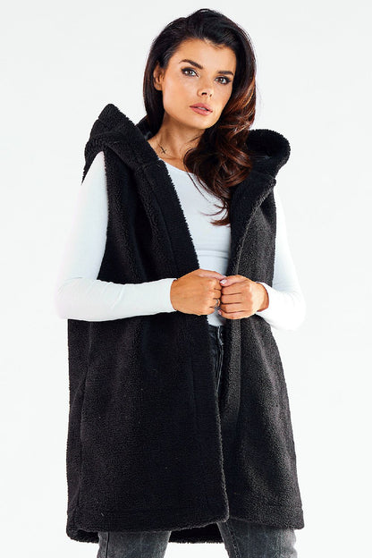 Chic woman wearing an elegant black hooded gilet vest, featuring a luxurious texture and stylish silhouette, perfect for stylish layering on cool days.