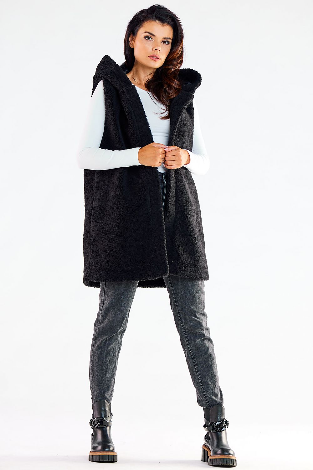 Fashionable model showcasing a trendy black hooded gilet vest, designed for comfort and versatility, complemented with sophisticated denim for a casual yet elegant look.