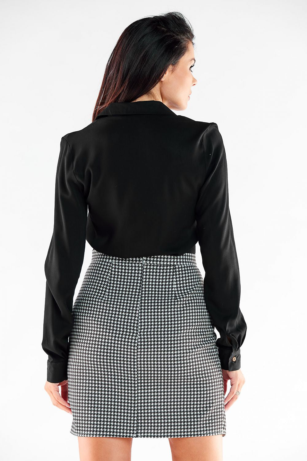Elegant back view of a model wearing a stylish asymmetrical mini skirt by Awama, paired with a chic black blouse, showcasing a sophisticated look.