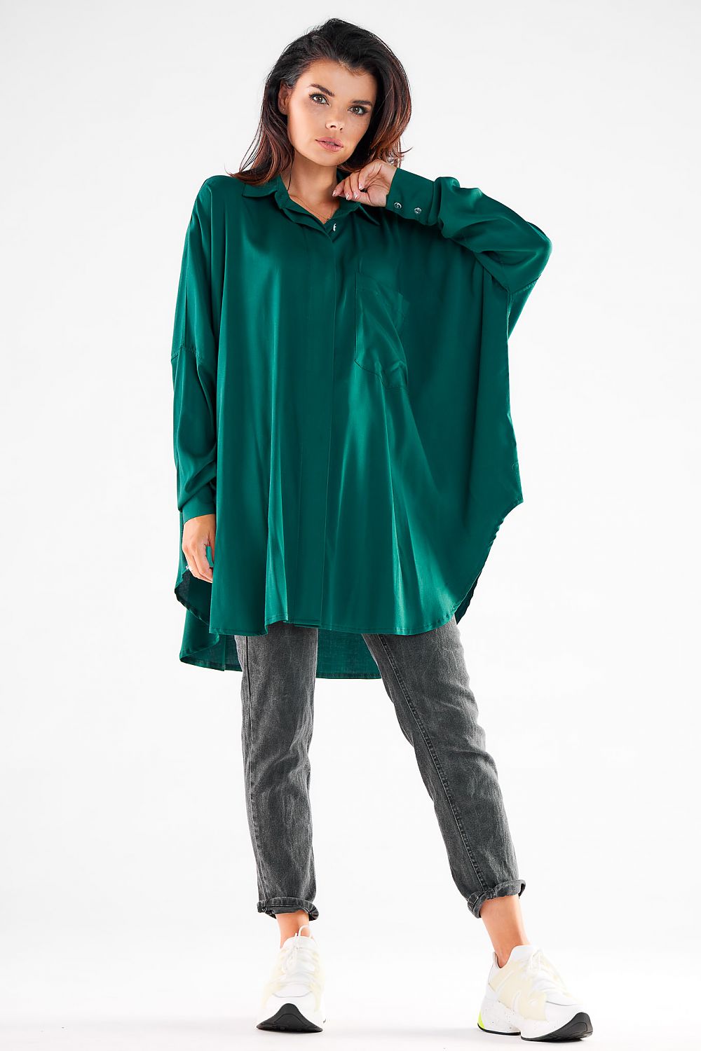 Sophisticated women's green oversized shirt, designed for comfort and elegance, worn with trendy grey jeans, ideal for both casual and elegant outings.