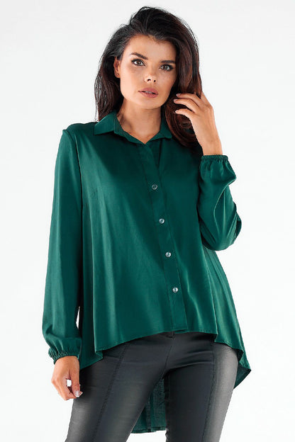 Luxurious green long sleeve shirt with an extended back and button details, paired with slim imitation leather trousers, embodying modern urban chic.