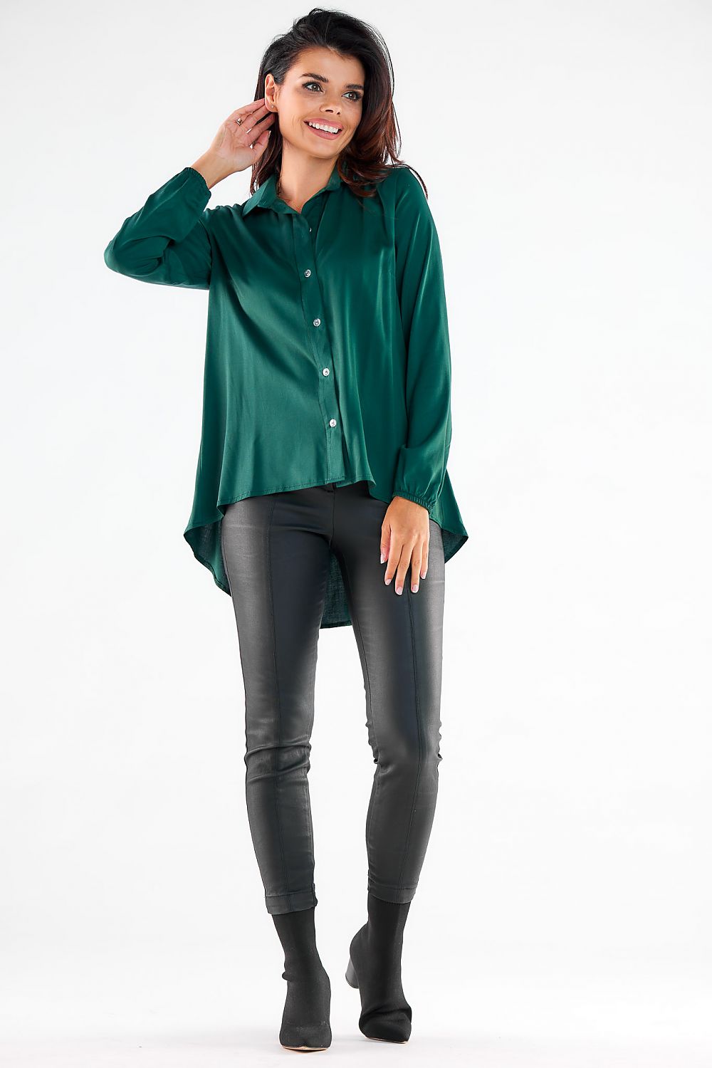 Trendy green long sleeve shirt showcasing a relaxed silhouette and stylish button-up front, elegantly styled with fitted imitation leather pants for an urban look.