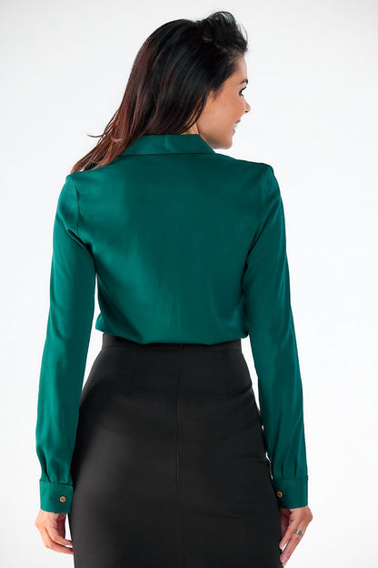 Back view of a chic green long-sleeve shirt by Awama, showcasing clean lines and a tailored fit, elegantly paired with a black skirt for a polished appearance.