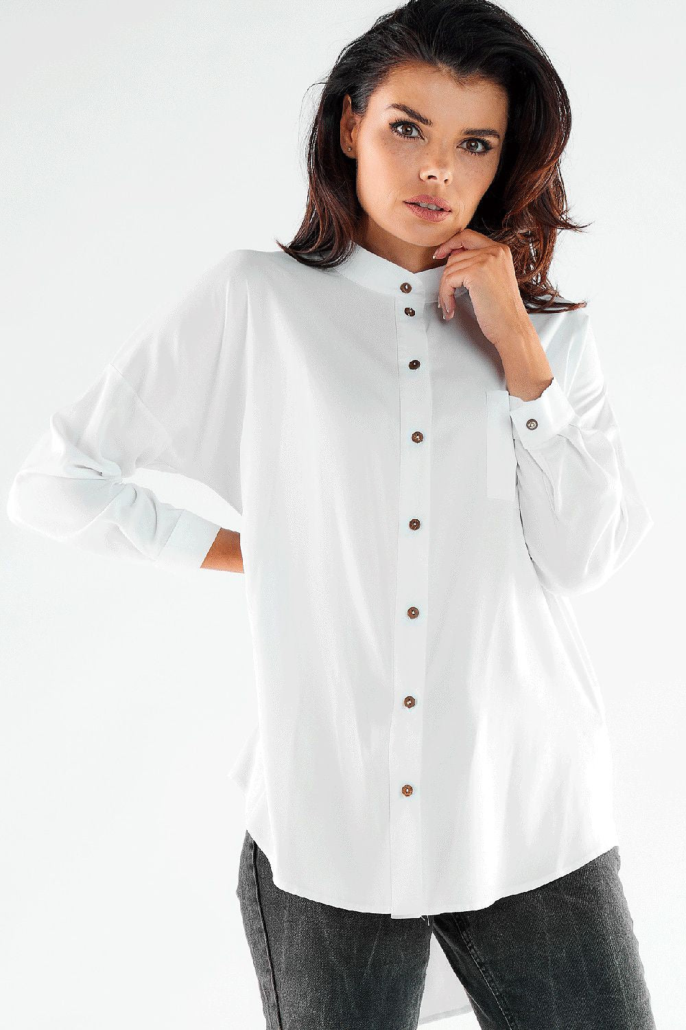 Elegant long sleeve white buttoned shirt with an extended back, worn by a stylish model, designed by Awama in Poland for a sophisticated look.