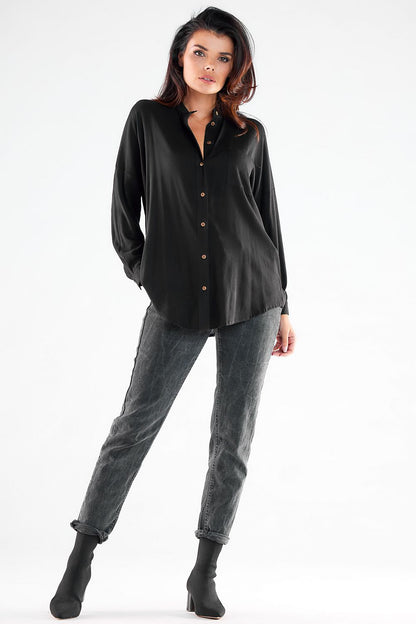 Chic black long sleeve buttoned shirt with extended back worn stylishly by a model, perfect for both casual and business settings.