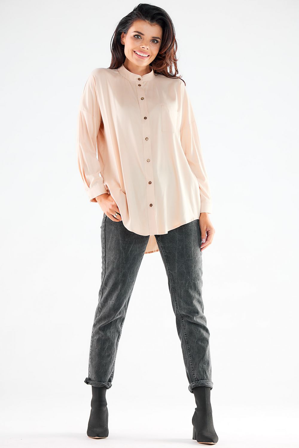 Fashion-forward light peach long sleeve buttoned shirt, styled with tailored trousers, ideal for upscale casual wear.