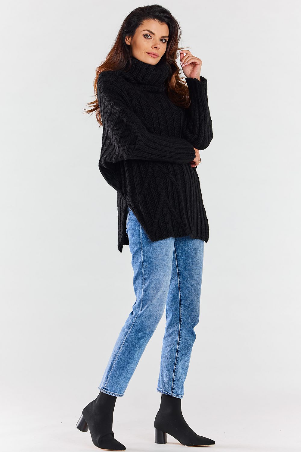 Sophisticated black luxury women's turtleneck sweater displayed in a modern pose, emphasizing the cable knit details and versatile layering potential.