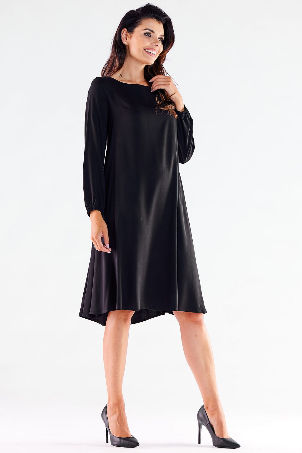 Sophisticated black trapezoidal daydress with long sleeves, emphasising a sleek and elegant silhouette, designed for stylish occasions, posed elegantly.