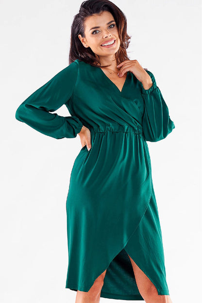 Elegant long-sleeved green Awama cocktail dress featuring a V neckline and a sultry thigh-high slit, showcasing feminine style. Perfect for chic occasions.