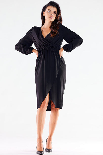 Fashion-forward front view of a model in a black long-sleeved Awama cocktail dress with a stylish V neckline and a sophisticated slit, perfect for upscale occasions.