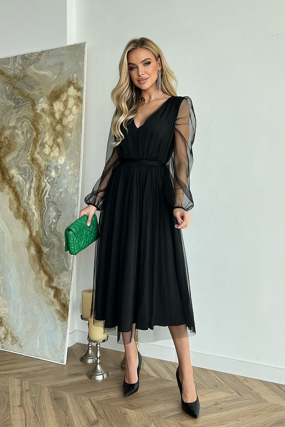 Sophisticated black midi dress with billowing sleeves, showcased alongside a green clutch, embodying luxury and classic elegance for refined occasions.