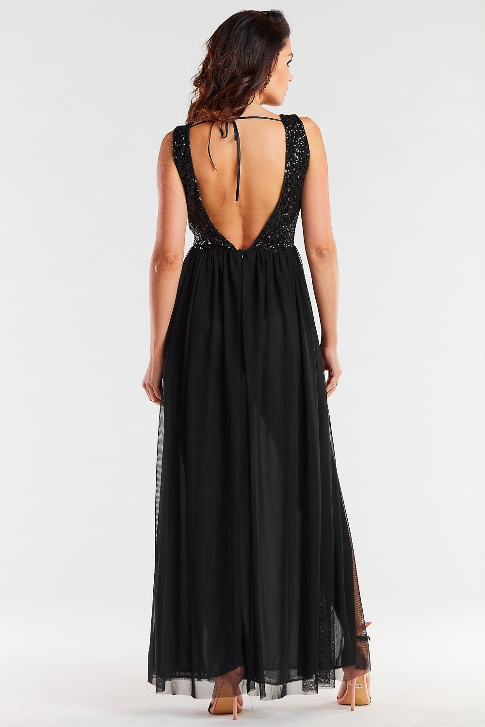 Elegant view of the back of a black sequin dress, designed with an open back and flowing skirt, embodying sophisticated allure.